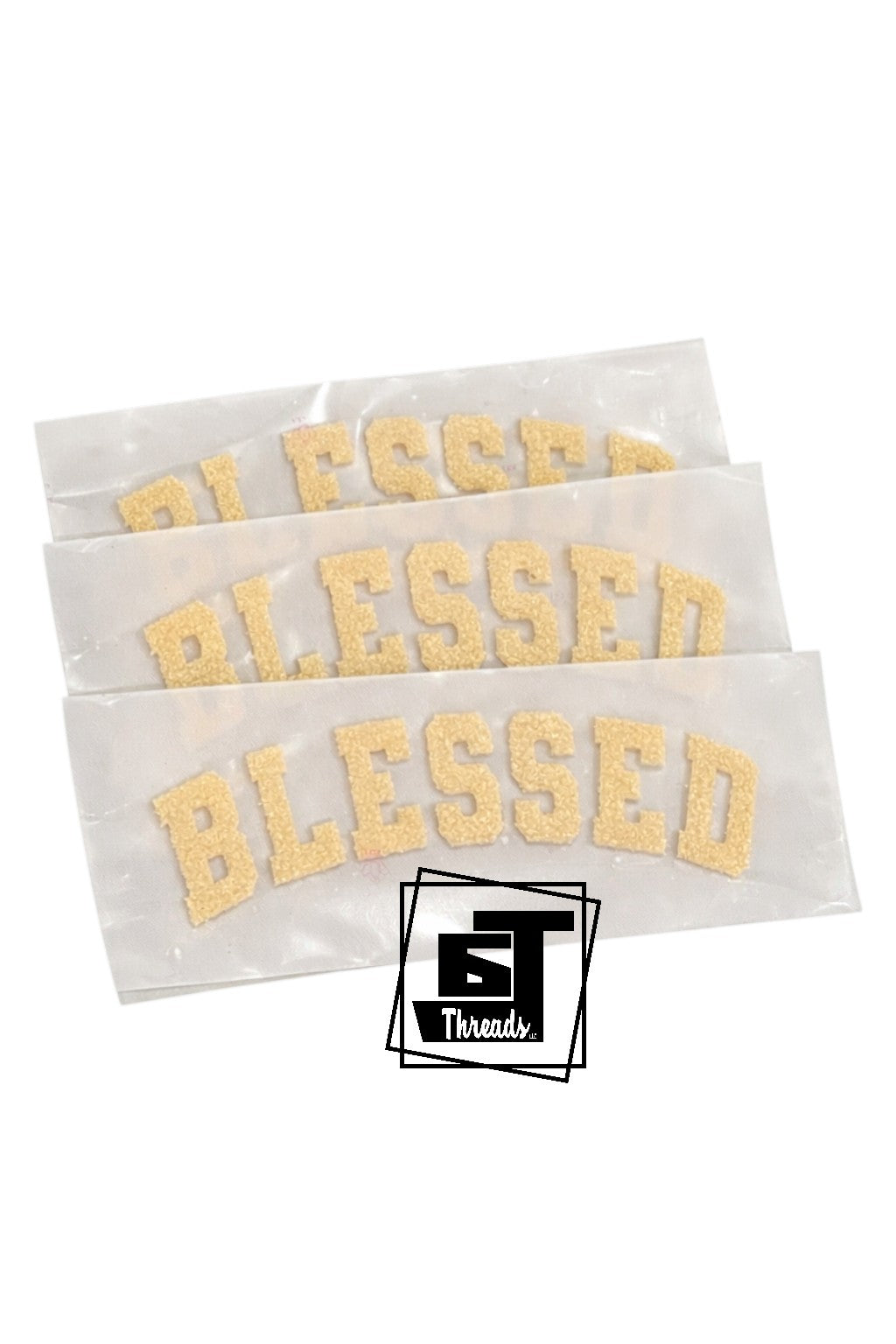 Three white paper strips with 'Blessed' printed in gold, featuring a logo in the corner.