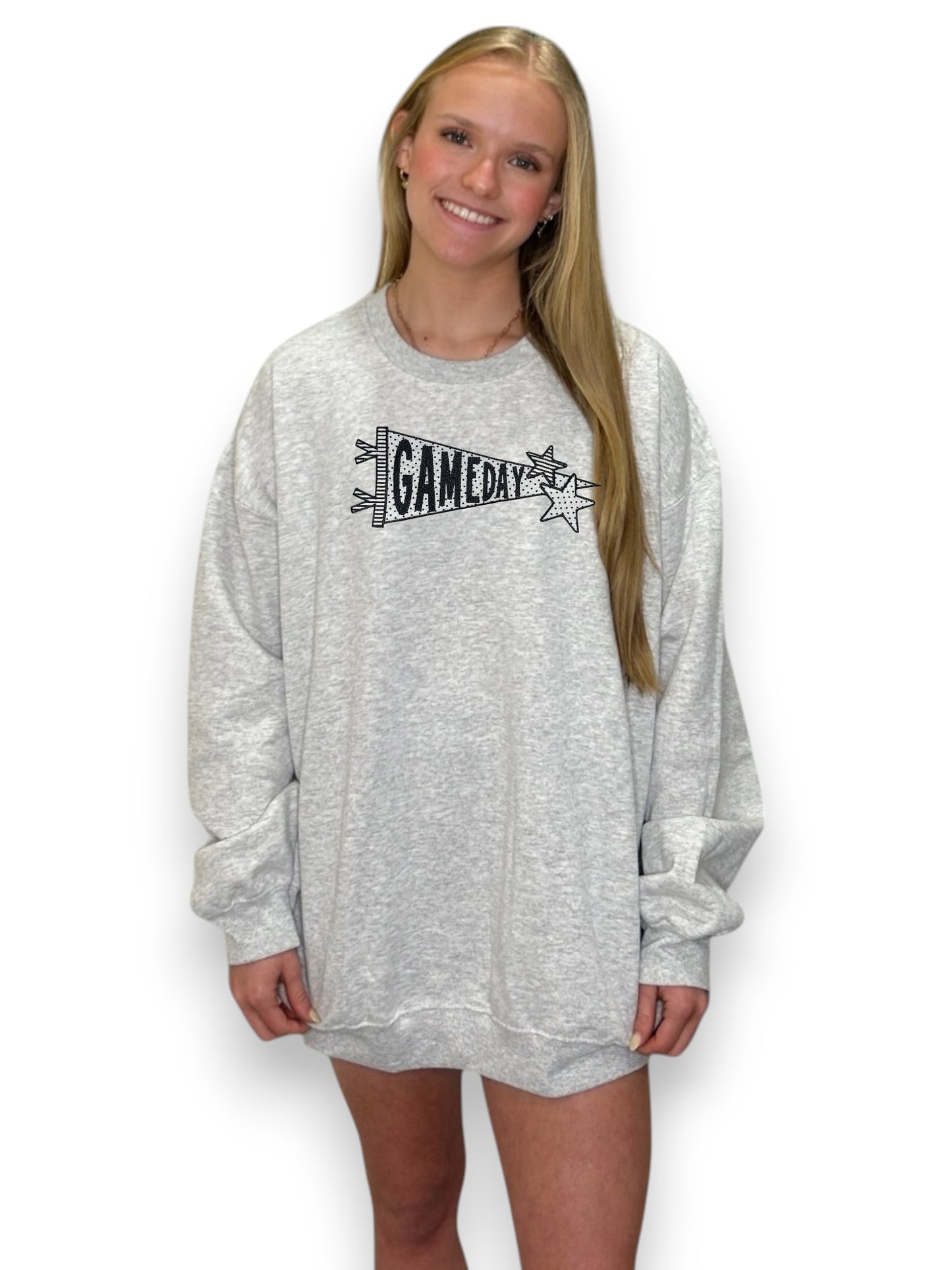 Person wearing a gray sweatshirt with 'GAMEDAY' text on a white background