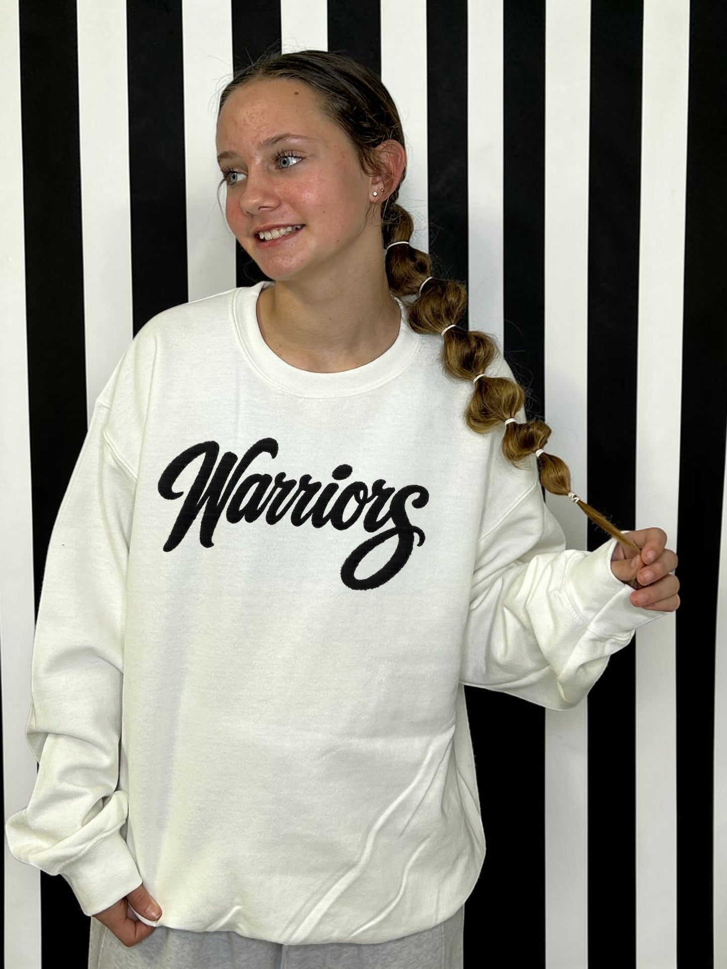 warriors' black fuzzy patch with white sweatshirt on a white and black striped background
