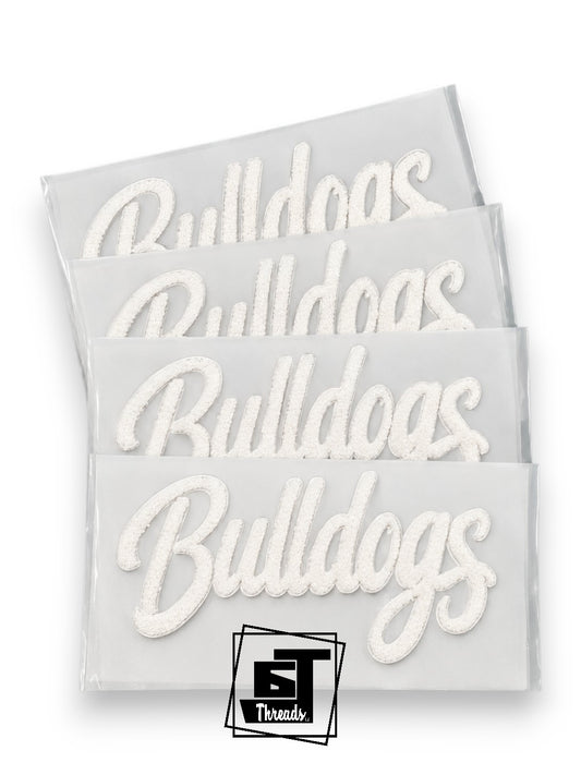 Four white embroidered patches with the word 'Bulldogs' in cursive script, stacked diagonally on a white background with a Threads logo at the bottom.