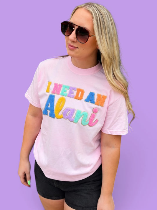 Person wearing a pink t-shirt with colorful text against a purple background