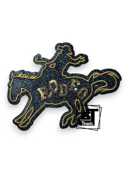 Measurements 6 inches wide by 5 inches tall
Black glitter fabric Bronc rodeo patch with gold embroidery and gold sequin rodeo
Iron-on Patch