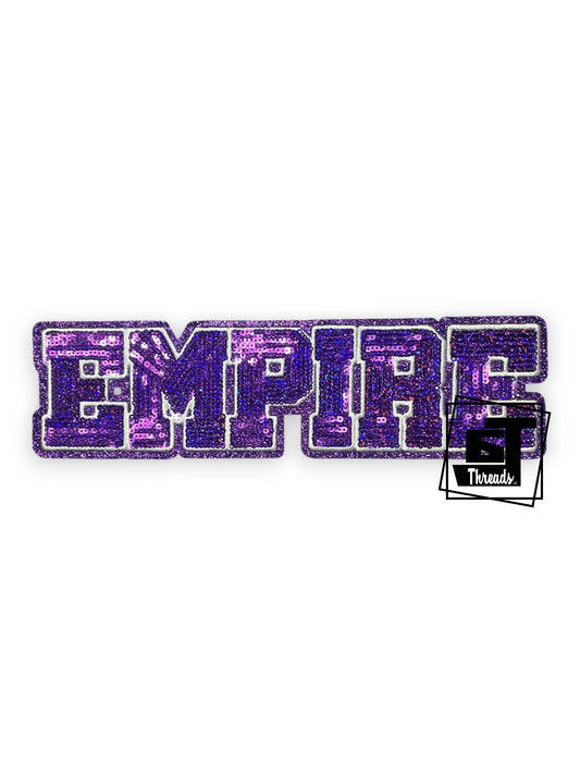 Measurements: 9.5 inches wide by 2.5 inches tall
Purple sequin block empire with white embordiery and purple glitter background
Iron-on Patches