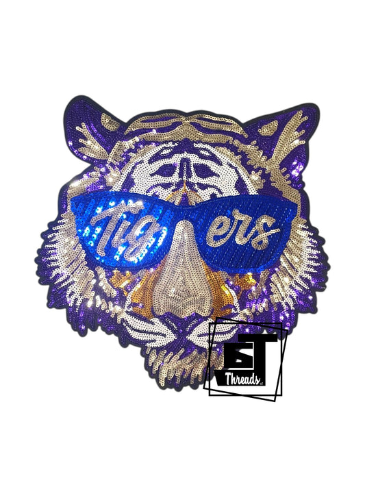 Embroidered patch of a tiger wearing sunglasses with 'Tigéus' text on a white background.