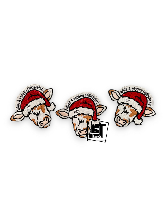 Three identical cartoon cow holiday pins wearing Santa hats, arranged horizontally on a white background.