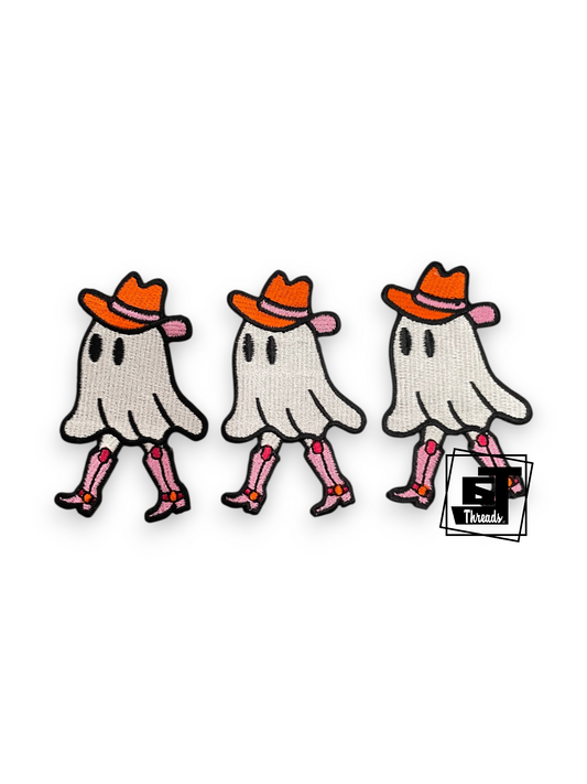 Three identical embroidered ghost patches wearing orange cowboy hats and pink boots, shown on a plain white background with a small 'Trends' logo overlay near the bottom right.