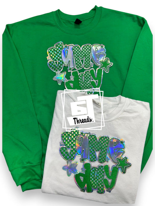 green metallic checkered game day patch on green sweatshirt and white shirt