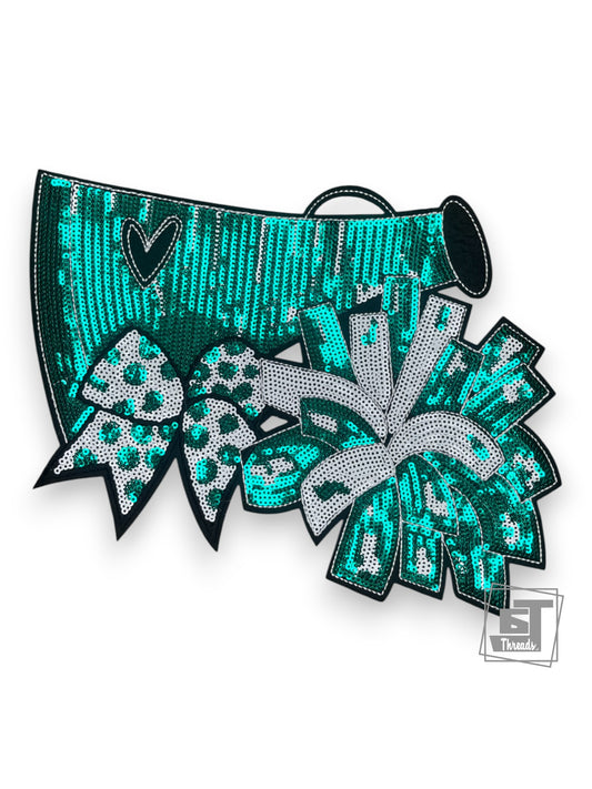 Teal sequin hair bow with decorative elements on a white background