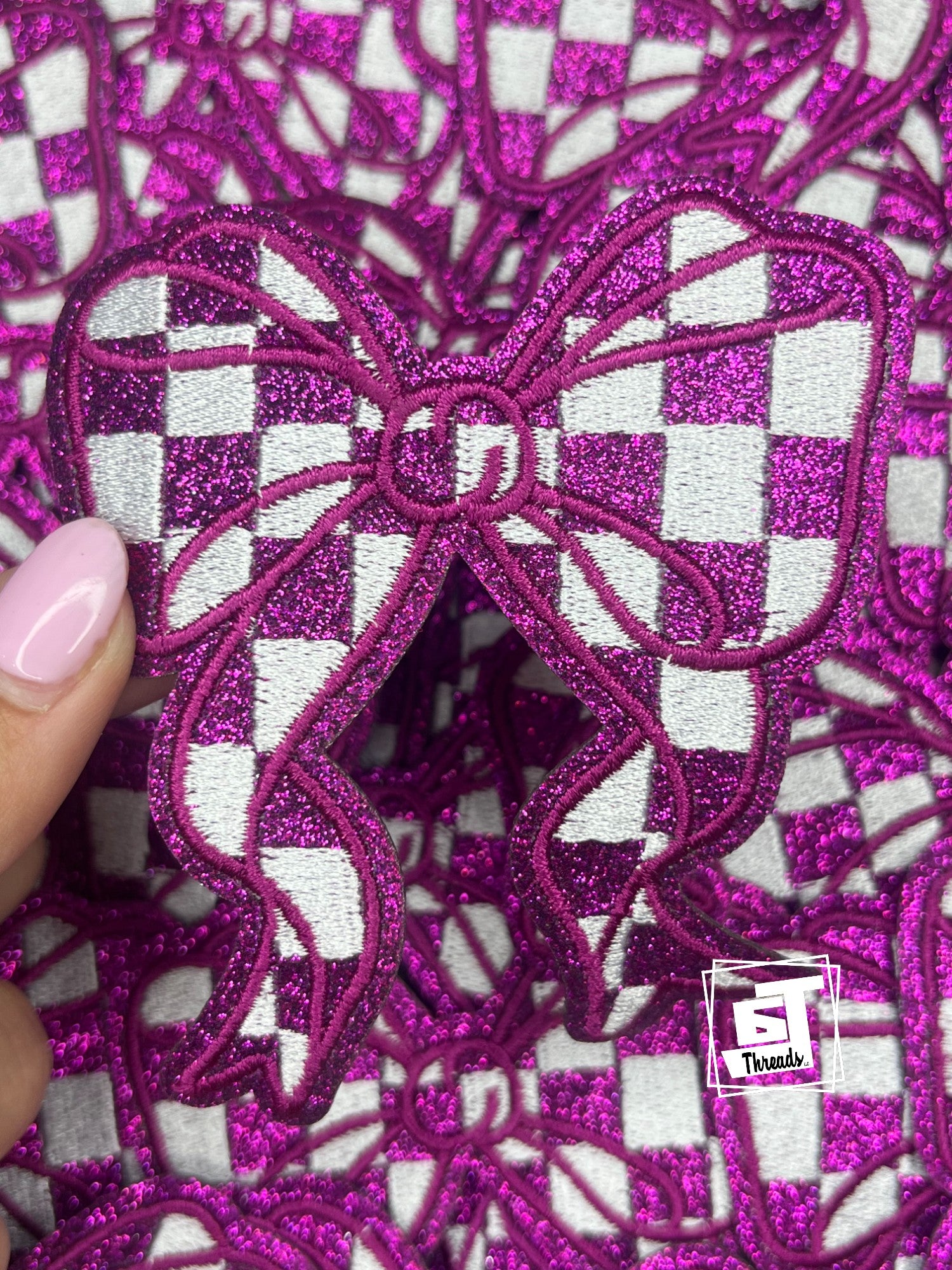 Close-up of pink glittery butterfly design on a checkered fabric background