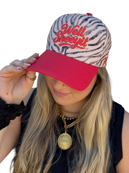 Person wearing a zebra print and red baseball cap with 'Well Sheezy Fit' text.