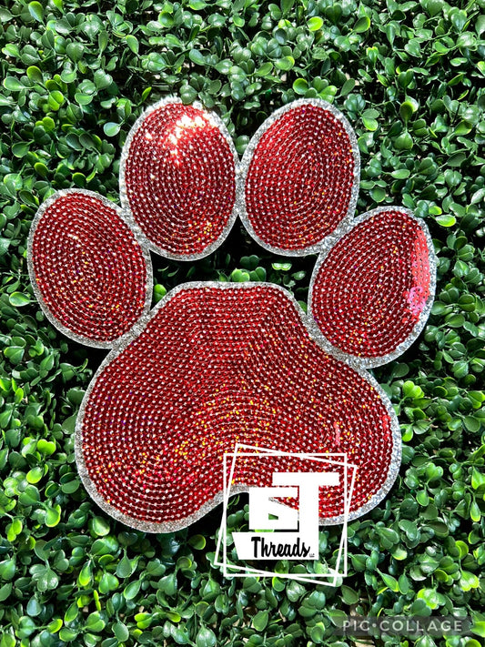 Red rhinestone paw print on a green grass background with 'ST Threads' logo.