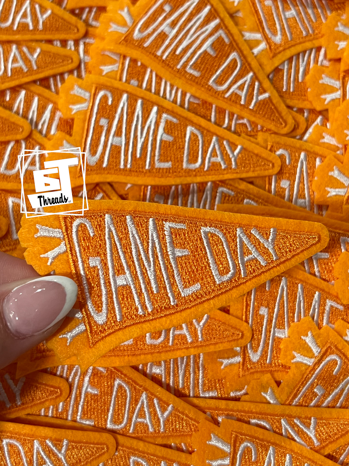 Orange 'GAME DAY' patches with a hand holding one, branded with ET Threads.