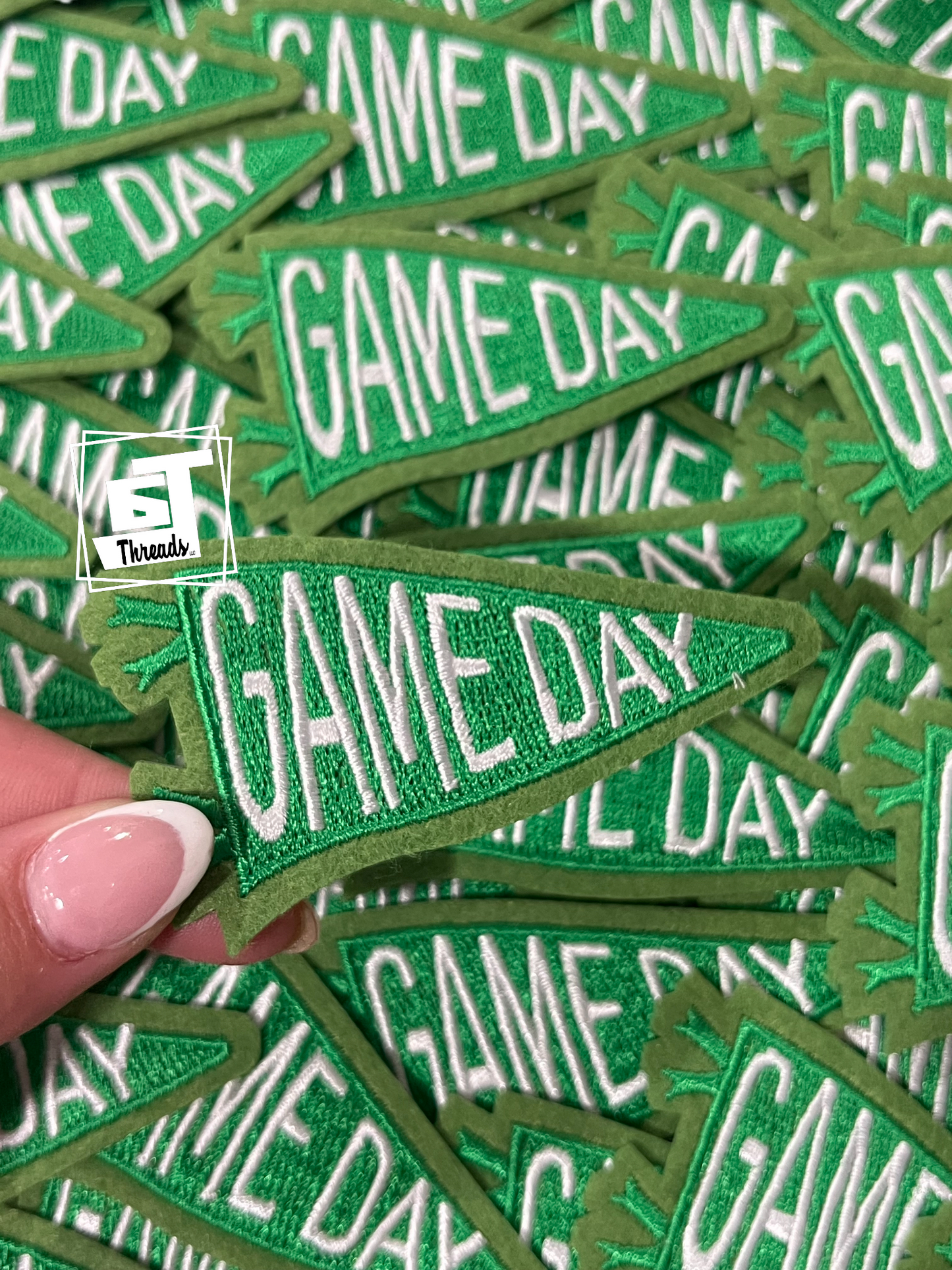 Green 'GAME DAY' patches with a hand holding one patch, brand logo visible.