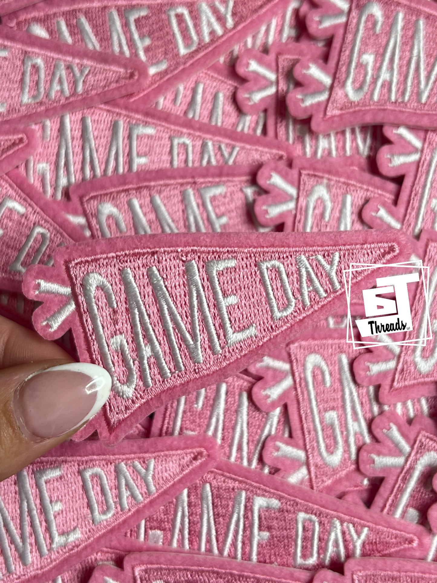Pink patches with 'GAME DAY' text and a hand holding one of them.