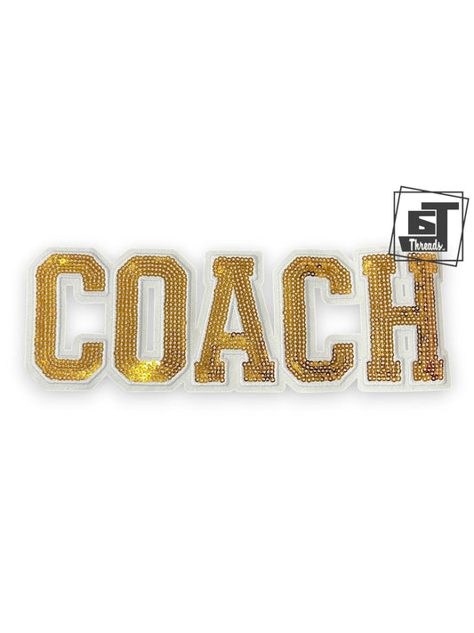 Gold 'COACH' patch with a brand logo on a white background