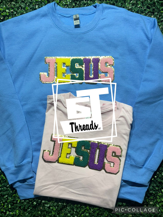 Chenille block letter Jesus on a blue crewneck