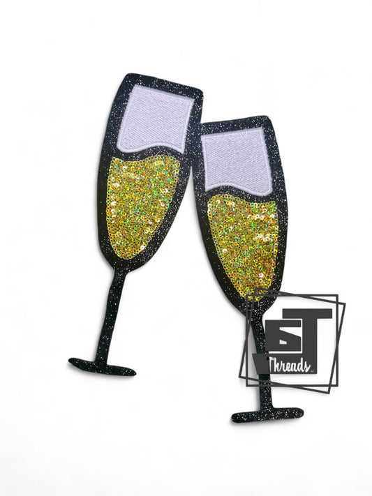 Measurements 8 inches tall by 5.5 inches wide
Gold sequin champagne glasses with black emboreriy and white background
Iron-on patch