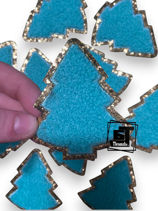 Blue Christmas tree with gold edges on a white background, with a hand touching one of them.
