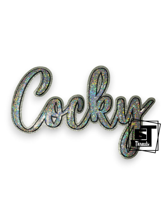 Measurements: 11.5 inches wide by 7 inches tall
Silver cursive sequin Cocky with black embroidery and silver glitter background
Iron-on Patch
