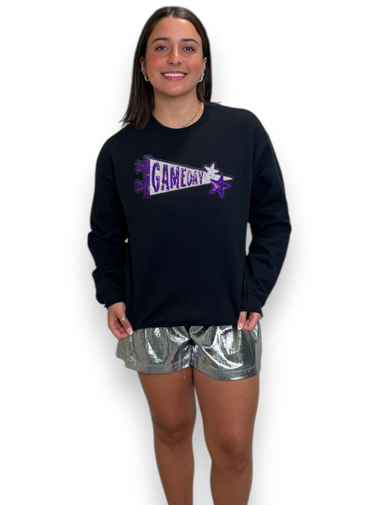 Person wearing a black long-sleeve shirt with 'Game Day' text and silver shorts on a white background