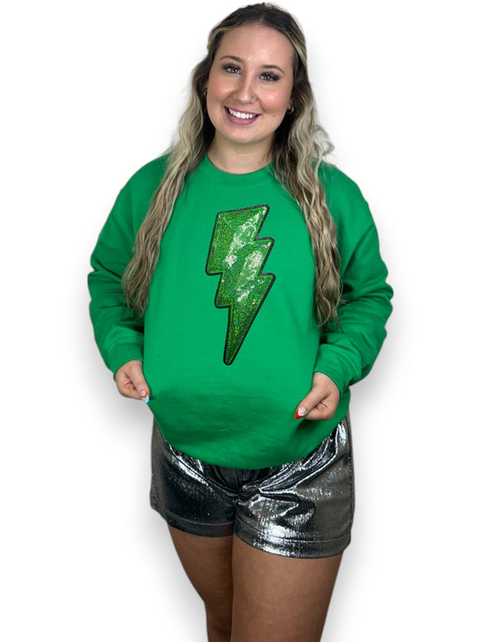 Person wearing a green sweatshirt with a lightning bolt design on a white background