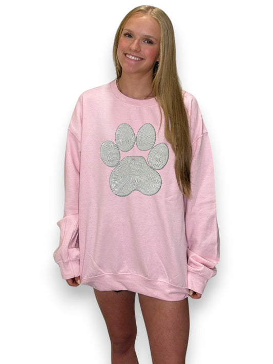 Person wearing a pink sweatshirt with a paw print design on a white background