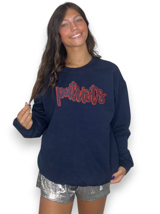 Woman wearing a navy sweatshirt with red text and silver shorts on a white background