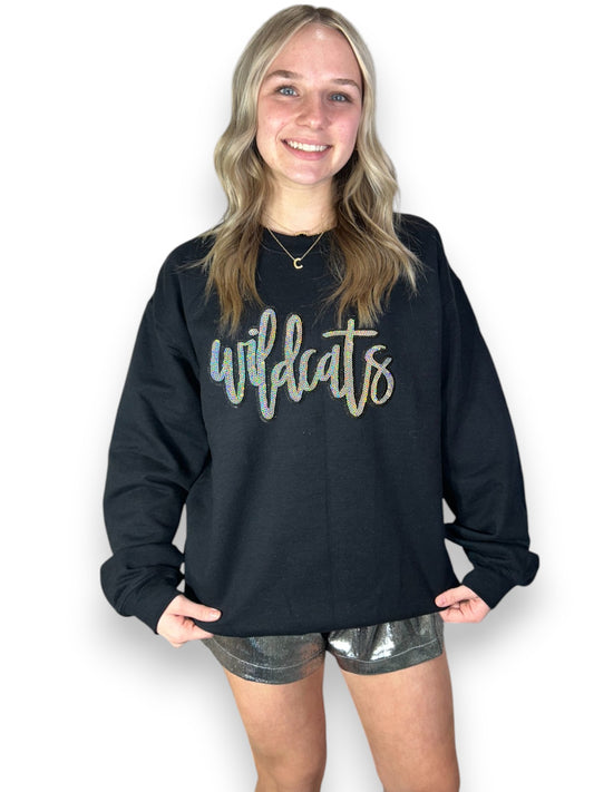 Person wearing a black sweatshirt with 'wildcats' text on a white background