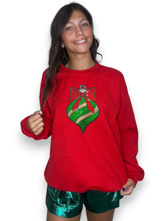 Person wearing a red sweatshirt with a green and gold design on a white background