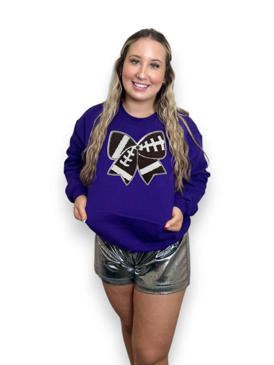 Woman wearing a purple sweatshirt with a black and white design on a white background