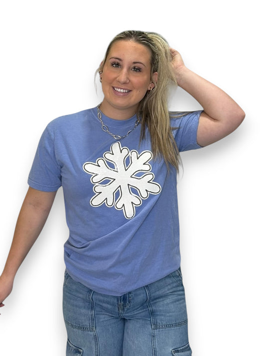 Woman wearing a blue t-shirt with a white snowflake design on a white background