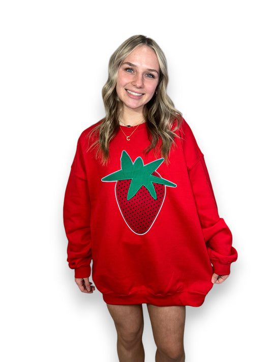 Person wearing a red sweatshirt with a strawberry design on a white background