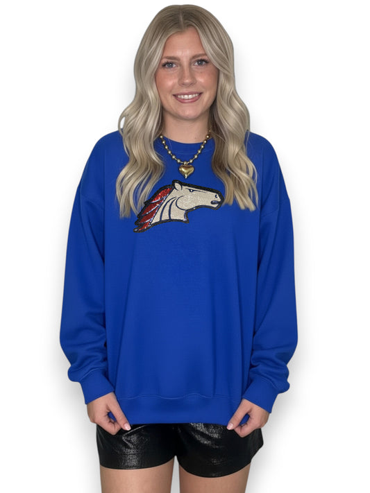 Woman wearing a blue sweatshirt with a horse graphic on a white background