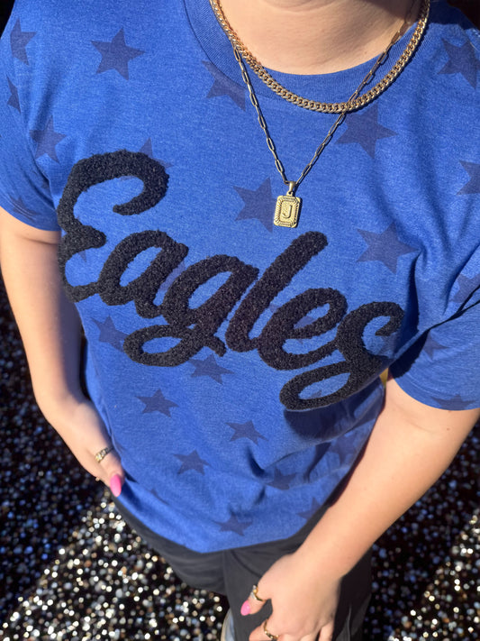 Person wearing a blue 'Eagles' shirt with star patterns on a dark background