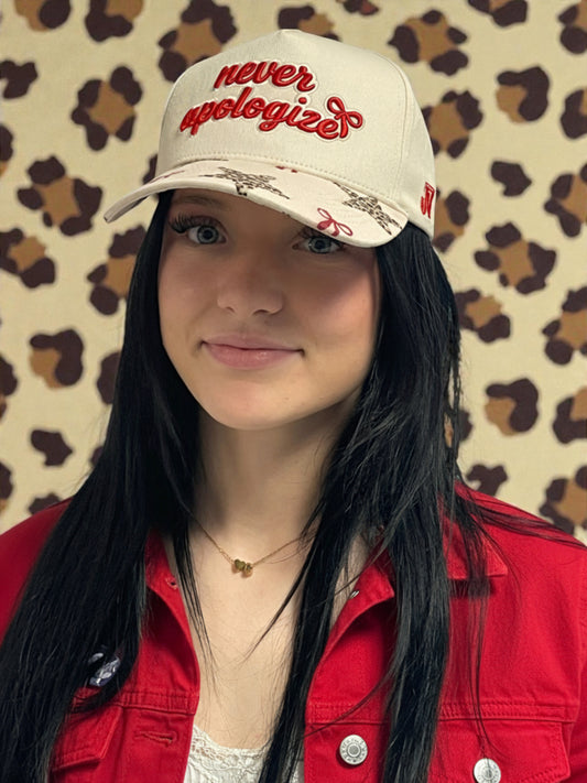 Person wearing a cap with 'never apologize' text against a patterned background