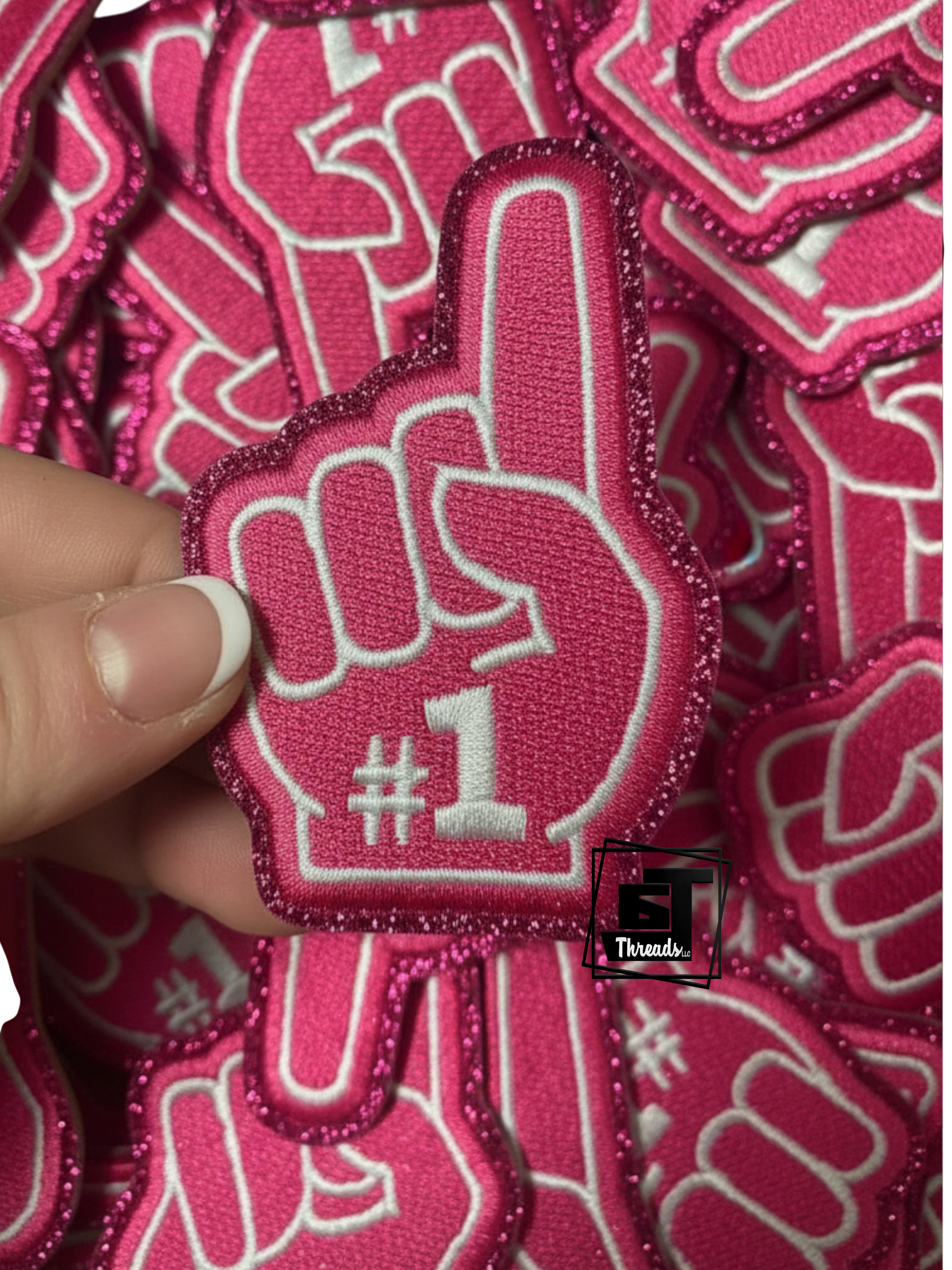 Pink patch with a hand giving a thumbs-up and the number 1 on a pink background.