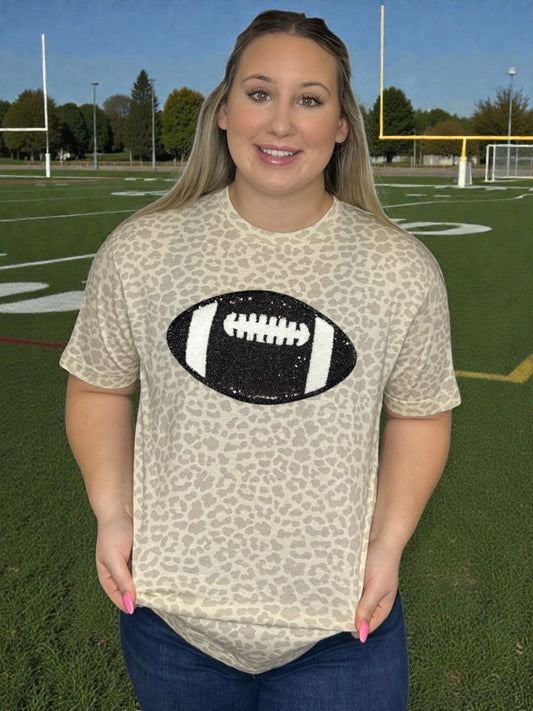 Person wearing a t-shirt with a football design on a sports field
